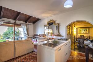 a kitchen and living room with a sink and a couch at Villa Sa Pintadera private pool in Stintino