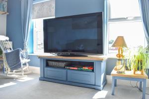 a blue entertainment center with a flat screen tv at Sanderlings - Suffolk Coastal Escapes in Pakefield