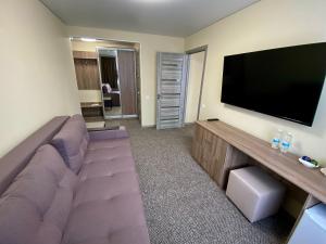 a living room with a couch and a flat screen tv at Yavir in Poltava