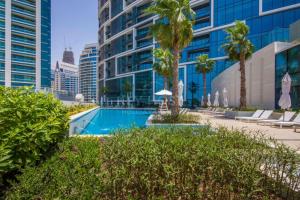 a swimming pool with palm trees and buildings at KeyHost - Stunning 1BR - The Address Beach Residences JBR -Dubai Marina View - K1470 in Dubai