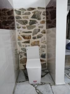 La salle de bains est pourvue de toilettes et d'un mur en pierre. dans l'établissement Lonos Circle Terrace view, à Romblon