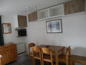 eine Küche mit einem Esstisch und Stühlen in der Unterkunft Au Coeur De La Station in Les Deux Alpes