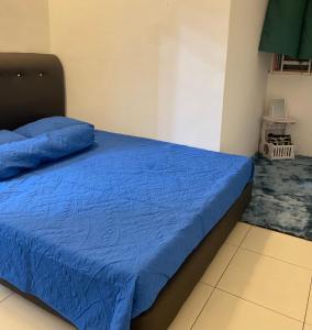 Schlafzimmer mit einem Bett mit blauer Decke in der Unterkunft Cik Misi Homestay in Sik