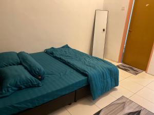 Bett mit grüner Decke in einem Zimmer in der Unterkunft Cik Misi Homestay in Sik