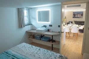 1 dormitorio con 1 cama y baño con lavamanos en Nieuw app met tuin en terras, gratis parking, aan zee, vlakbij Brugge en Duinbergen