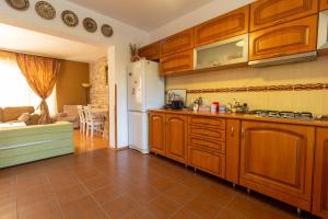 - une cuisine avec des placards en bois et un réfrigérateur blanc dans l'établissement Vila cu Mesteceni, à Câmpina