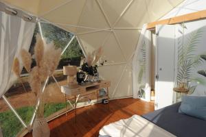 Camera con tenda, letto e tavolo di Melograno Bubble Glamping a Vasanello