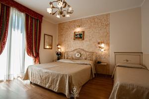 a bedroom with two beds and a chandelier at Viktoria Palace Hotel in Venice-Lido