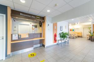 a hospital lobby with a yellow smiley face on the floor at B&B HOTEL Lieusaint Carré Sénart in Lieusaint
