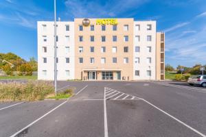 ein leerer Parkplatz vor einem Hotel in der Unterkunft B&B HOTEL Lieusaint Carré Sénart in Lieusaint