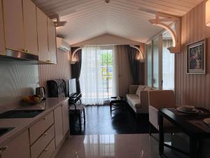 cocina y sala de estar con sofá y mesa en FLORIDA GARDEN PATTAYA, en Na Jomtien
