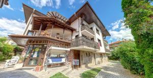 a large house with a balcony on top of it at Grami Hotel in Bansko