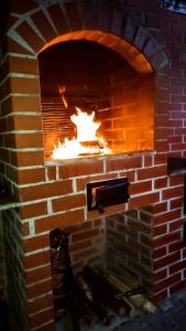 a brick oven with a fire in it at Farkaslaki Panoráma Vendégház in Lupeni