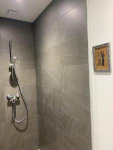 a shower in a bathroom with a tile wall at Locavilla - l'Estagnit in Puy-Saint-Eusèbe