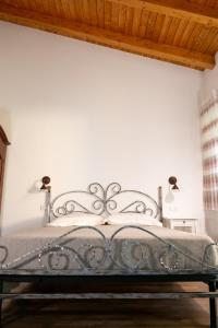 un letto in ferro in una camera da letto con soffitto in legno di Agriturismo Casa Chiara a Latina