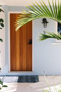 a wooden door in a house with a plant at The Blue Water, Dreamtime Beach in Kingscliff