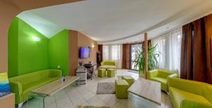 Elle comprend un salon doté d'un mobilier vert et d'un mur vert. dans l'établissement Grami Hotel, à Bansko