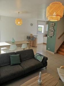 a living room with a couch and a dining room at Mer et calme in Frehel