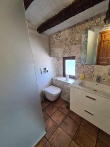 a bathroom with a toilet and a sink and a mirror at Casa Rural Las Tosquillas in Caravaca de la Cruz