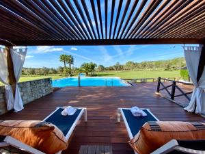 a patio with two beds and a swimming pool at Vila Valverde Design Country Hotel in Luz