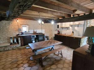 uma cozinha com uma mesa de madeira e um fogão em Authentiek landhuis met zwembad in Dordogne. 