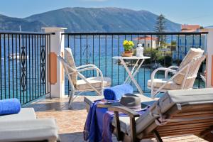 d'un balcon avec des chaises et une table offrant une vue sur l'eau. dans l'établissement Villa Ireni Waterfont, à Fiskardho