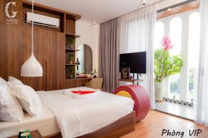 - une chambre avec un lit blanc et une grande fenêtre dans l'établissement Galaxy Hotel 3, à Hô-Chi-Minh-Ville