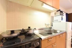 a kitchen with a stove with two pans on it at ノースウエストIR in Kita-rokujō