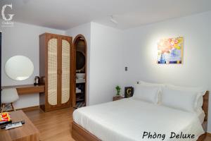 - une chambre avec un lit blanc et une table dans l'établissement Galaxy Hotel 3, à Hô-Chi-Minh-Ville