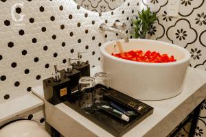 - un comptoir de salle de bains avec un lavabo et des poivrons rouges dans l'établissement Galaxy Hotel 3, à Hô-Chi-Minh-Ville