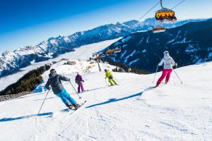 a group of people skiing down a ski lift at vomLandl Natur Lofts & Apartments Leogang in Leogang