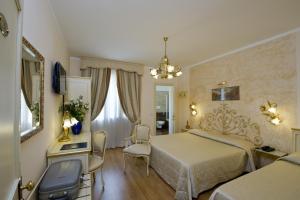 um quarto com uma cama, uma mesa e cadeiras em Viktoria Palace Hotel em Veneza-Lido