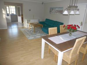 ein Wohnzimmer mit einem Tisch und einem blauen Sofa in der Unterkunft Ferienwohnung Wiesengrund in Bockholm