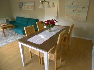 einen Esstisch und Stühle mit einer Blumenvase in der Unterkunft Ferienwohnung Wiesengrund in Bockholm