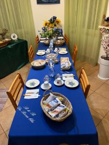 een lange blauwe tafel met een blauwe tafelkleed en stoelen bij La Rosa Blu Rende in Rende
