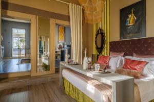 a bedroom with a large bed and a dining room at Maison Boutique At Uno in San Pietro in Lama
