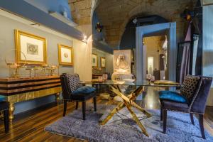 a living room with a glass table and chairs at Maison Boutique At Uno in San Pietro in Lama