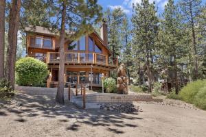 a large wooden house in the middle of trees at Cove Lakefront Chalet #2098 by Big Bear Vacations in Big Bear Lake