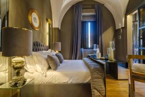 a bedroom with a bed and a table with a lamp at Maison Boutique At in San Pietro in Lama