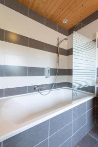 a bathroom with a bath tub with a shower at La Charbonnière, grand gîte haut-de-gamme avec jacuzzi et sauna in Gérardmer