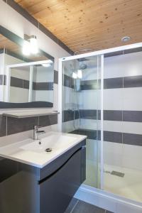 y baño con lavabo y ducha. en La Charbonnière, grand gîte haut-de-gamme avec jacuzzi et sauna, en Gérardmer