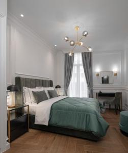 een slaapkamer met een groot bed en een kroonluchter bij Praxitelous Luxury Suites in Athene