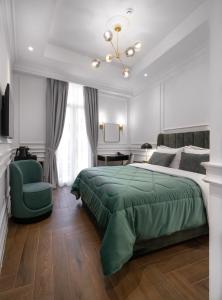 een slaapkamer met een groen bed en een groene stoel bij Praxitelous Luxury Suites in Athene