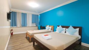 a room with two beds and a blue wall at RedDoorz @ Manila Airport Hotel in Manila