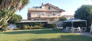 a yard with a table and an umbrella in front of a house at King Suite - con condizionatori vicino Aeroporto e Fiera di Roma in Fiumicino