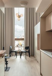 een woonkamer met een tafel en stoelen en een raam bij UNITY Helsinki in Helsinki