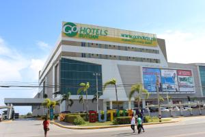 a hotel building with people walking in front of it at Go Hotels Butuan in Butuan