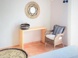 a room with a wicker chair and a table and a mirror at Joyanna Villa Pool, Sea View & Olive Grove Serenity in Mani in Kalívia