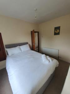 a bedroom with a large white bed with towels on it at Newcastle Park House in Stoke on Trent