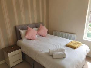 a bedroom with a bed with pink and white pillows at Newcastle Park House in Stoke on Trent